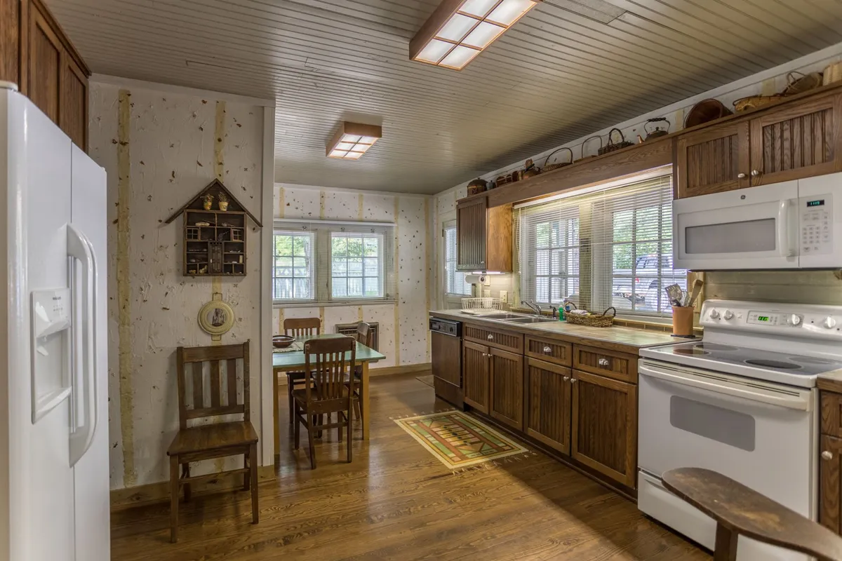 A bright kitchen scene featuring kitchen cabinets, a dining table set near a window that lets in natural light, and modern appliances. The setup encourages cooking together, sharing conversations, and enjoying quiet moments with coffee.